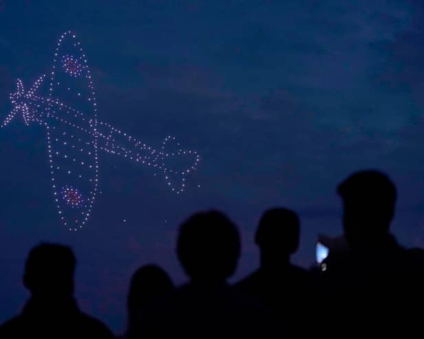 Drones make a Spitfire during a drone display telling the story of D-Day above the coastline in Southsea